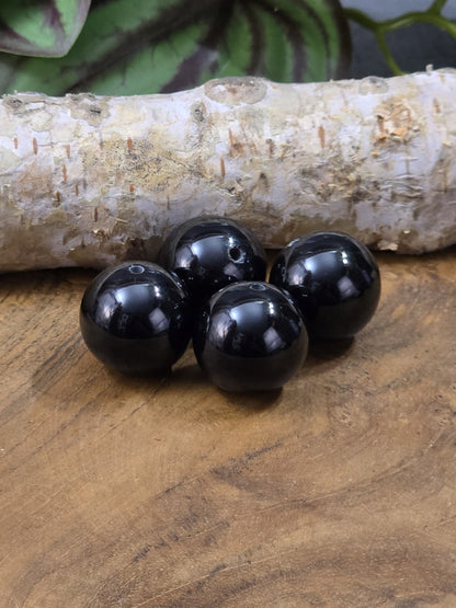 Vier schwarze Onyx-Perlen mit glänzender Oberfläche und Bohrung für DIY-Schmuck