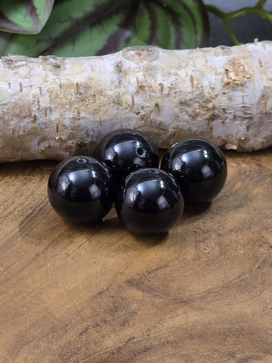 Vier schwarze Onyx-Perlen mit glänzender Oberfläche und Bohrung für DIY-Schmuck