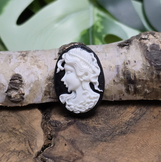 Das Bild zeigt einen ovalen Kamee-Cabochon – 25 x 18mm – Schwarz mit weißem Relief – Vintage-Charme für deine DIY-Kreationen