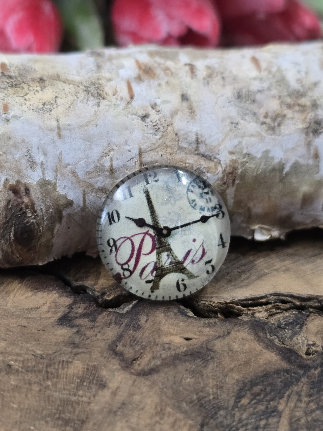 Nahaufnahme eines einzelnen 16 mm Cabochons aus Glas mit französischem Poststempel, Eiffelturm und Uhr-Motiv zum Basteln von Ketten und Ohrringen.