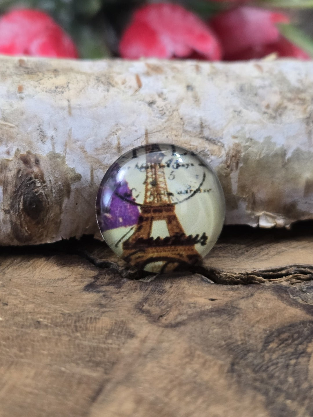 Nahaufnahme eines einzelnen 16 mm Cabochons aus Glas mit französischem Poststempel-Motiv und Eiffelturm als Zubehör zum Basteln von Ohrringen oder Ketten.