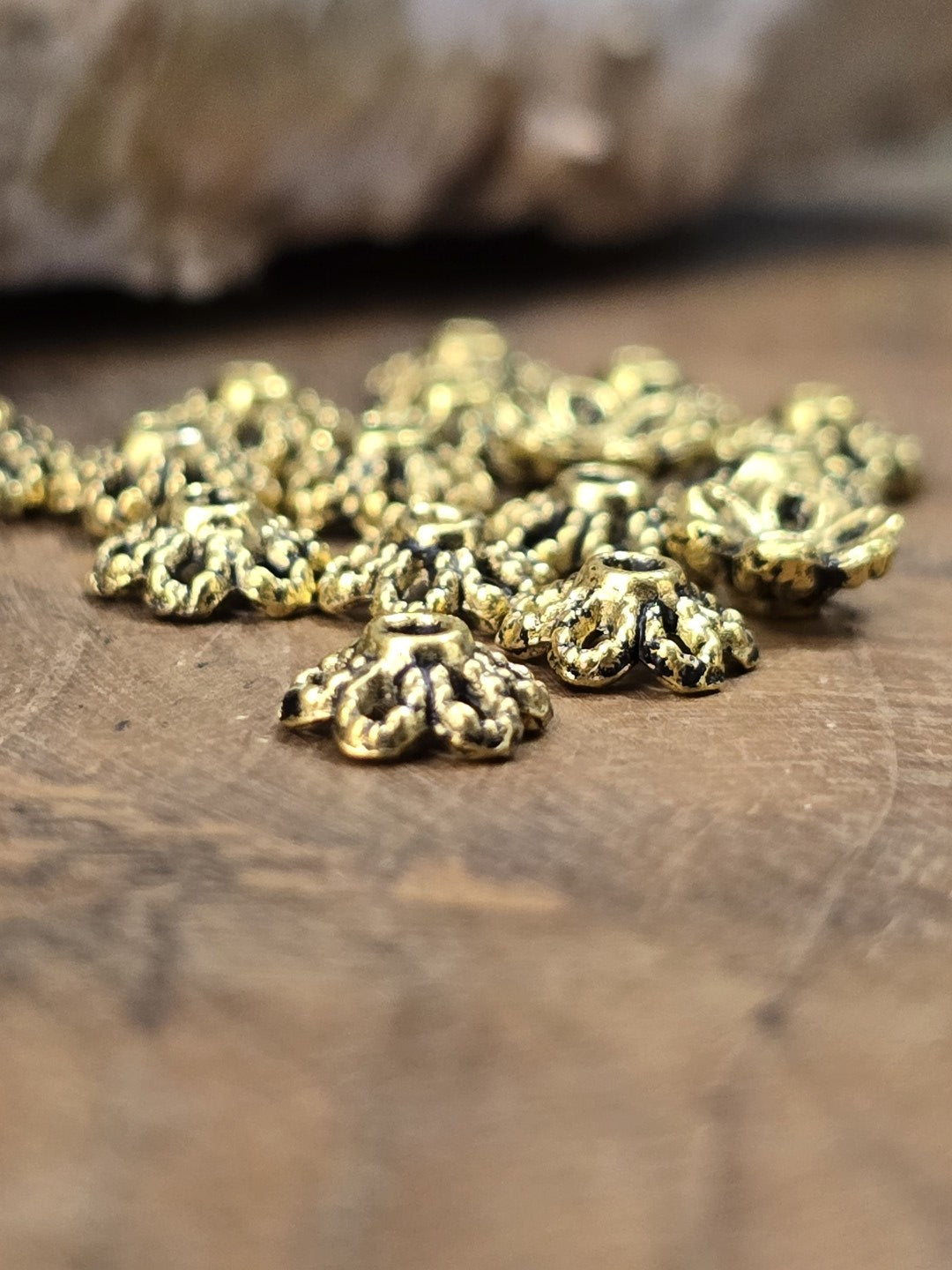 Detailaufnahme antik goldener Perlenkappen mit floralem Muster für Schmuckherstellung