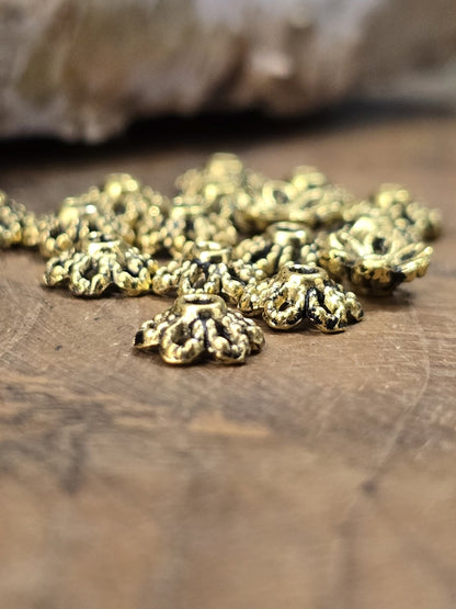 Detailaufnahme antik goldener Perlenkappen mit floralem Muster für Schmuckherstellung