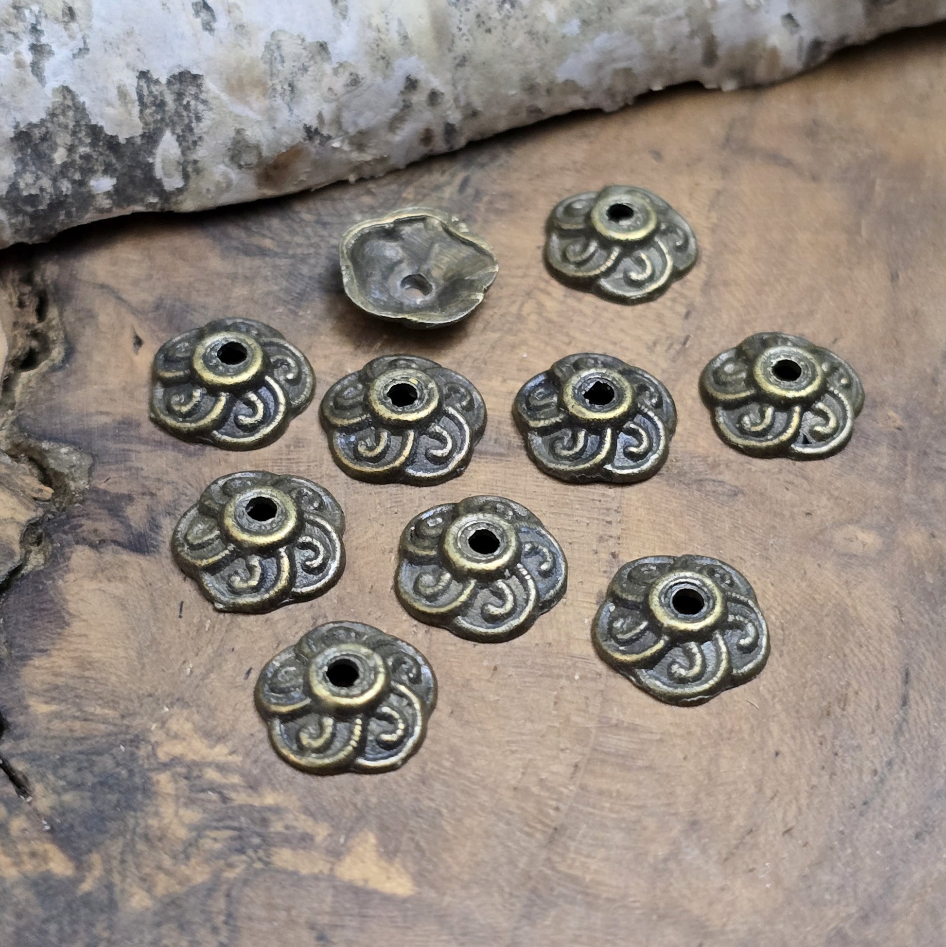 Das Bild zeigt Perlenkappen 9mm - antik bronzefarbig

Diese antik bronzefarbigen Perlenkappe sind ideal zum Setzen von Akzenten in Perlenketten und Armbändern, sowie zum Schützen der Perlen.

Sie können auch als rustikale Akzente auf Holzkisten (mit Nägeln) verwendet werden oder zum Scrapbooken.