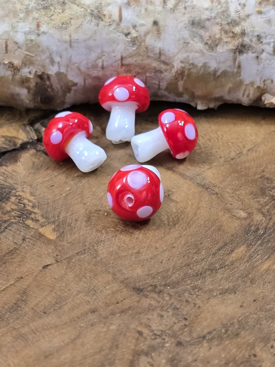 Kleine glänzende Glasperlen in Fliegenpilzform für märchenhaften DIY-Schmuck