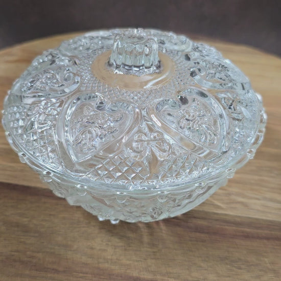 Vintage-Style Bonbonniere aus gepresstem Glas, KIG Malaysia. Schönes Relief, aber Randmacken vorhanden. Maße Ø13 cm, H9 cm, ca. 391 g. Vorsicht beim Reinigen.