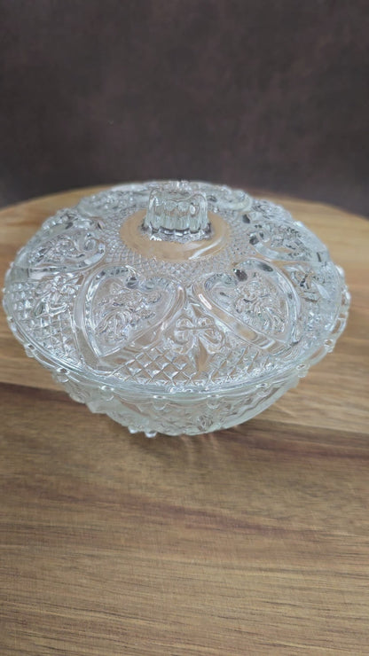 Vintage-Style Bonbonniere aus gepresstem Glas, KIG Malaysia. Schönes Relief, aber Randmacken vorhanden. Maße Ø13 cm, H9 cm, ca. 391 g. Vorsicht beim Reinigen.