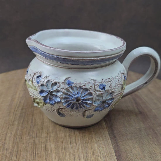 Kleiner Krug im Landhausstil, ca. 1970, handgefertigt – vermutlich Ainring Keramik. Mit floraler Reliefverzierung – perfekt für deine Vintage Wohnung oder als Geschenk.