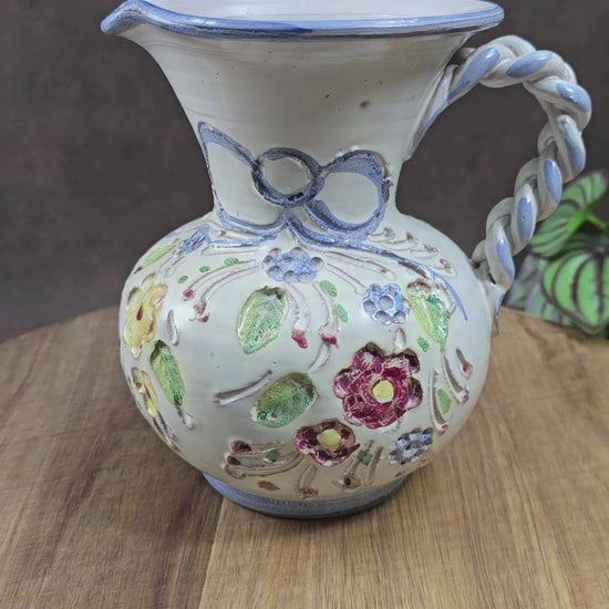 Vintage-Krug von Ainring Keramik, 1970er Jahre. Handarbeit mit Blumendekor & geflochtenem Griff. Leichte Unregelmäßigkeiten – ein echtes Unikat mit Charme!

