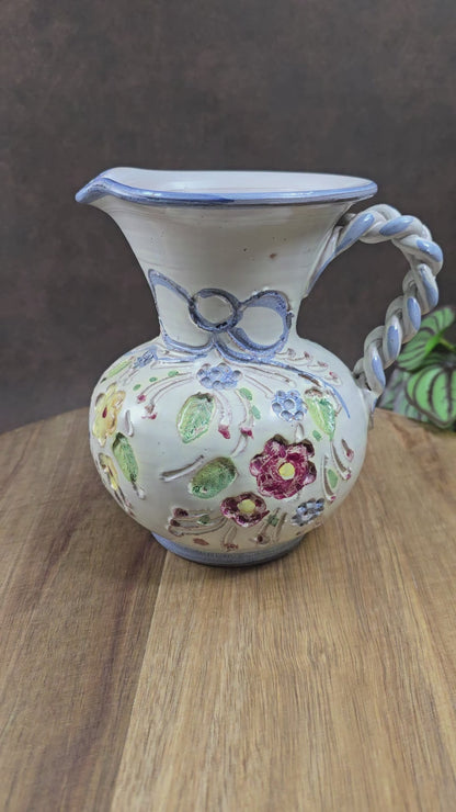 Vintage-Krug von Ainring Keramik, 1970er Jahre. Handarbeit mit Blumendekor & geflochtenem Griff. Leichte Unregelmäßigkeiten – ein echtes Unikat mit Charme!


