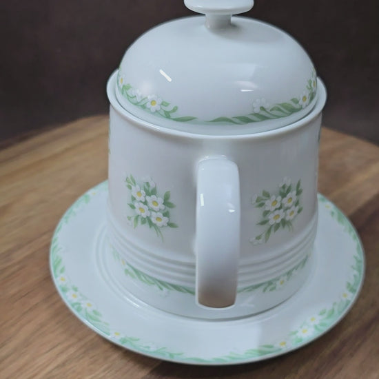 Kleine Vintage-Kaffeekanne aus Porzellan von Melitta Friesland, inkl. Teller. Fröhliches Blümchendekor, ideal für Kaffee- oder Teegenuss.
