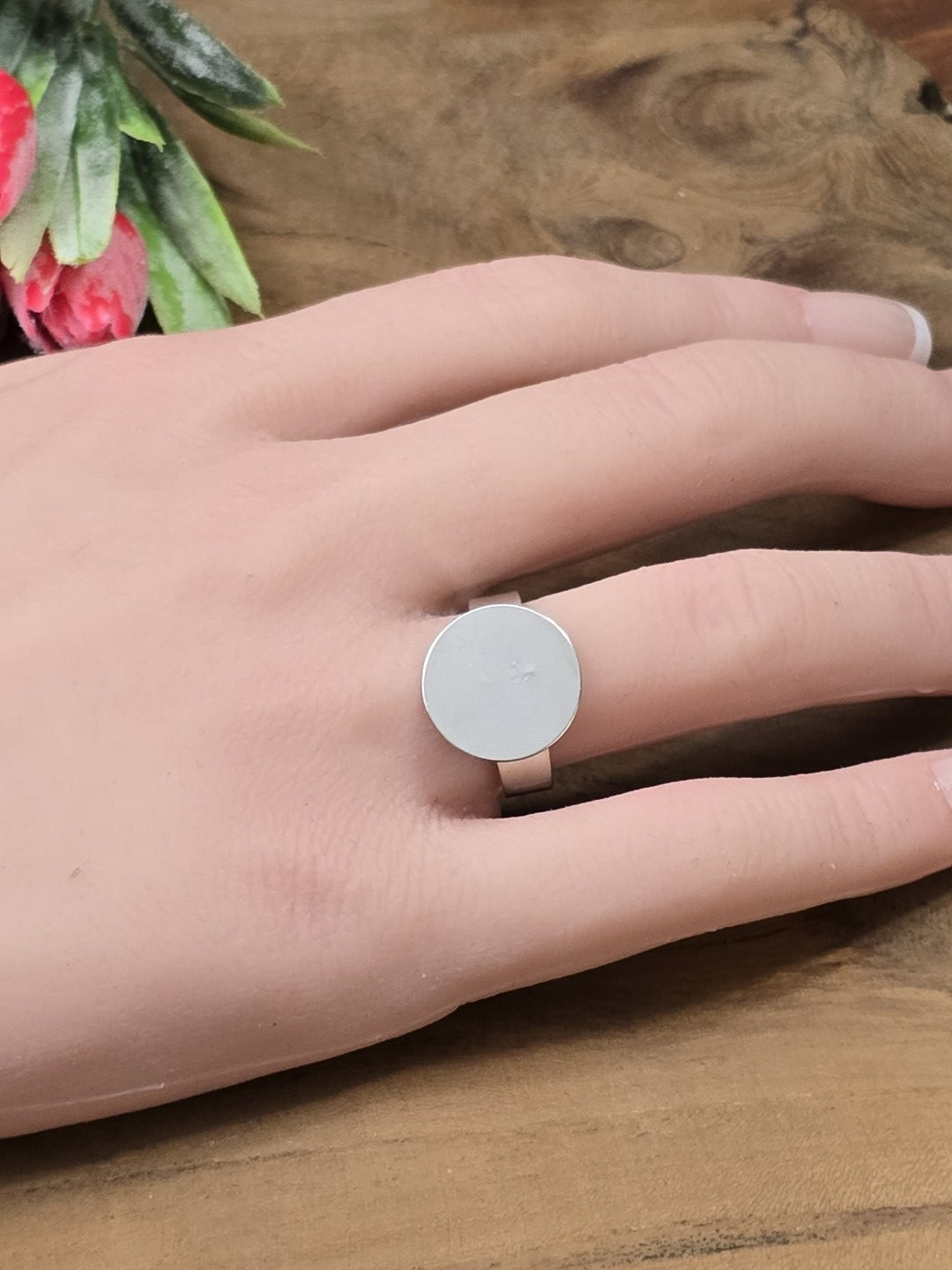 Silberner verstellbarer Ringrohling mit runder 15mm Klebeplatte an der Hand als Größenvergleich für Cabochons.