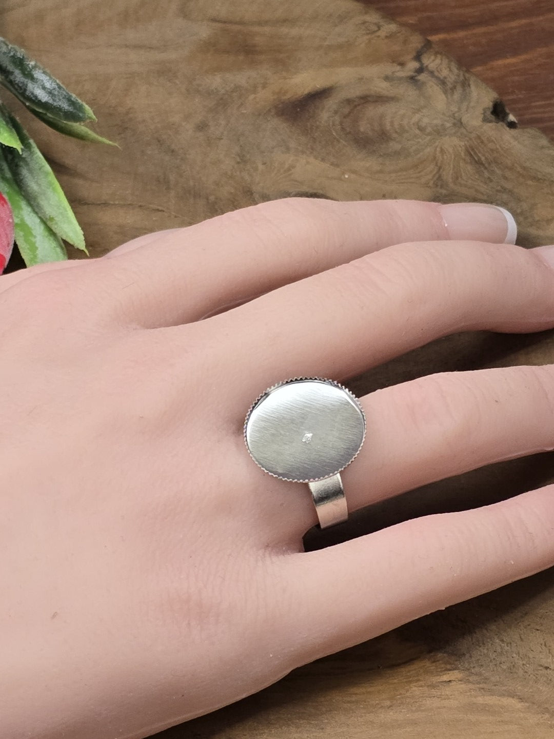 Silberfarbener verstellbarer Ringrohling mit runder 18mm Klebefläche für Cabochons getragen an der Hand als Größenvergleich.