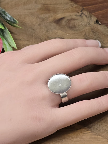 Silberfarbener verstellbarer Ringrohling mit runder 18mm Klebefläche für Cabochons getragen an der Hand als Größenvergleich.