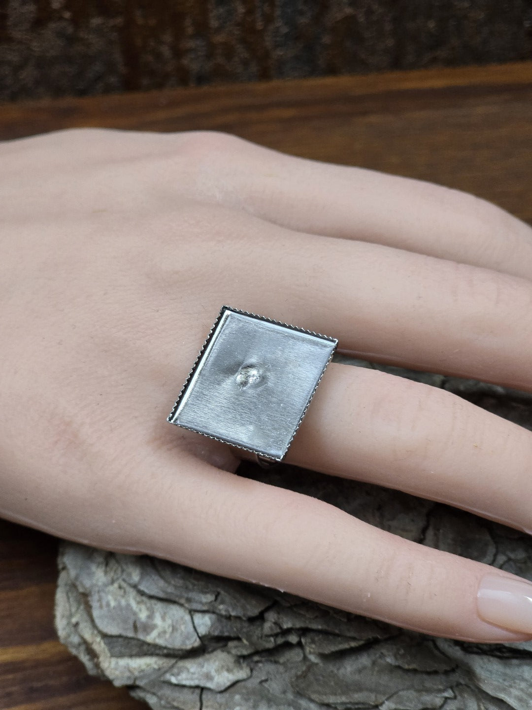 Silberner verstellbarer Ring mit quadratischer 19-mm-Platte an einer Hand zur Veranschaulichung der Größe und Passform.