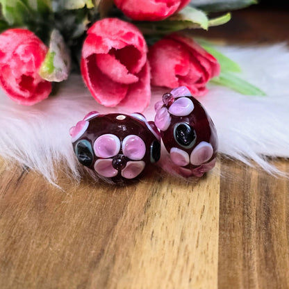 2 rote Glasperlen in Rondellform mit Bumps & Blumen in Rosa, Weiß & Grün – handgefertigt in Indien, perfekt für auffällige Schmuckstücke mit Persönlichkeit.