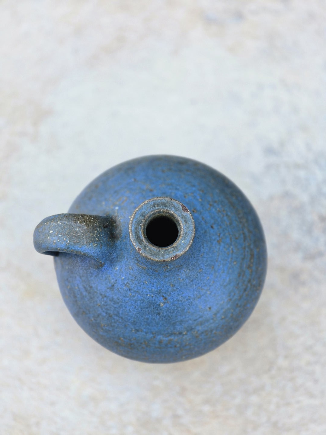 Vintage Studiokeramikvase von Rudi Stahl aus Höhr-Grenzhausen in kräftigem Blau mit matter Struktur, bauchiger Silhouette, Henkel und rotbraunem Scherben.