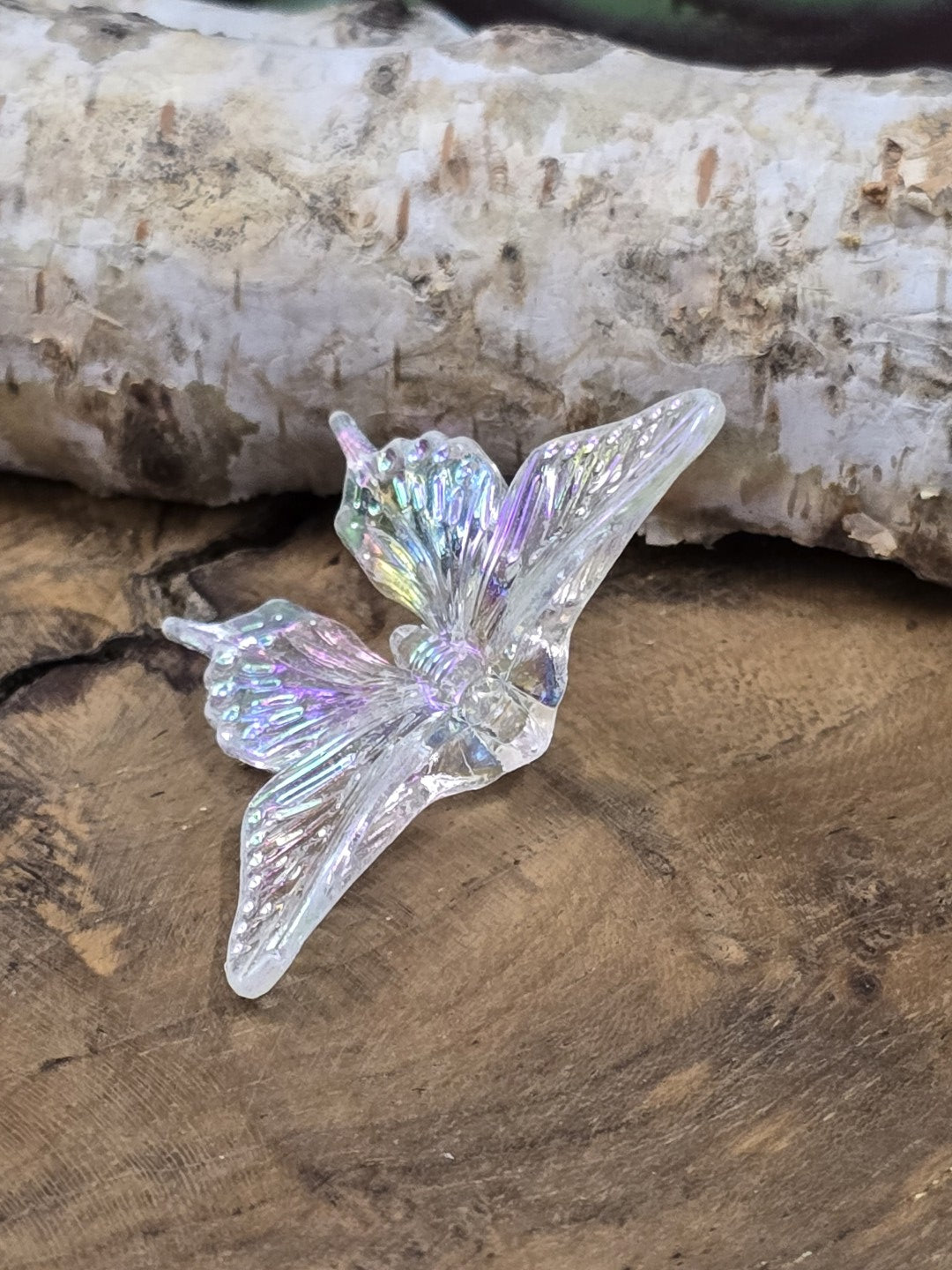Transparente Schmetterlingsperle mit violetten, grünen und rosafarbenen Lichtreflexen
