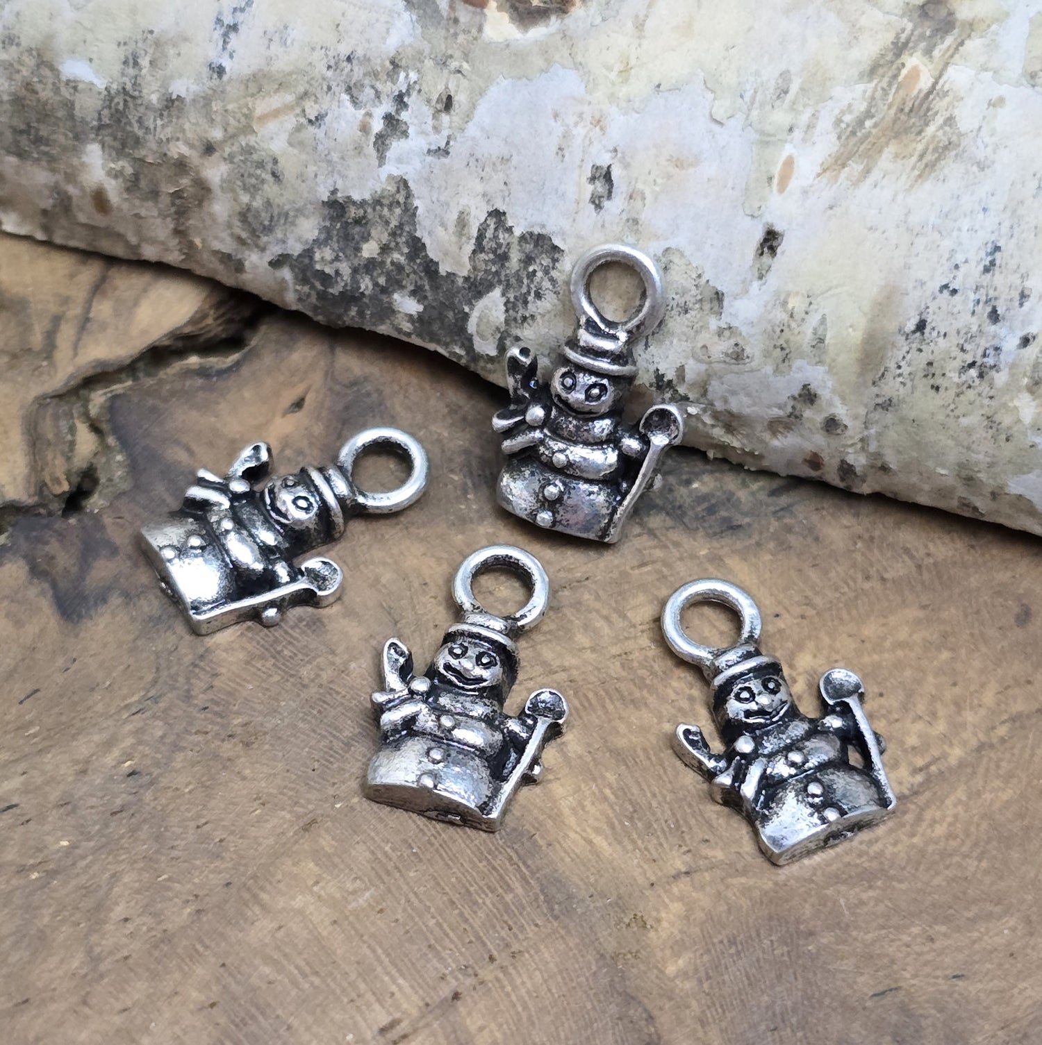 20 kleine Anhänger in Form von Schneemännern, silberfarben mit einem charmanten Antikfinish, perfekt für die kreative Schmuckgestaltung. Ideal für winterliche oder festliche Schmuckstücke, die eine besondere, nostalgische Note erhalten.