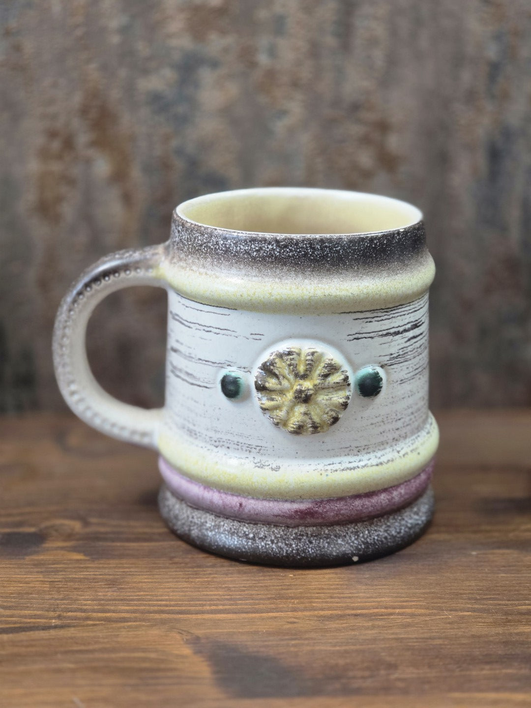 Vintage Keramikbecher von Strehla mit Henkel, gelbem Blütenrelief und grünen Akzenten in seitlicher Gesamtansicht