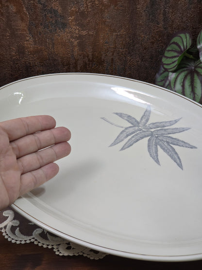 Vintage Porzellan Servierplatte mit grauem Blattdekor und Goldrand, Hand als Größenvergleich in schräger Ansicht