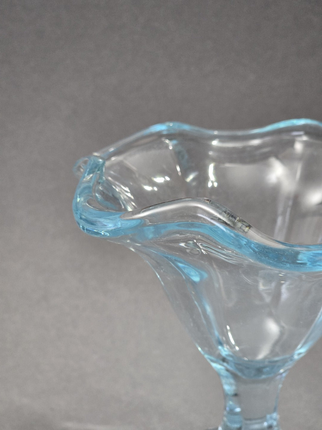 Die Draufsicht zeigt den hellblauen Rand, die transparente kelchförmige Schale und die leicht gerippten Pressglasflächen im Inneren.