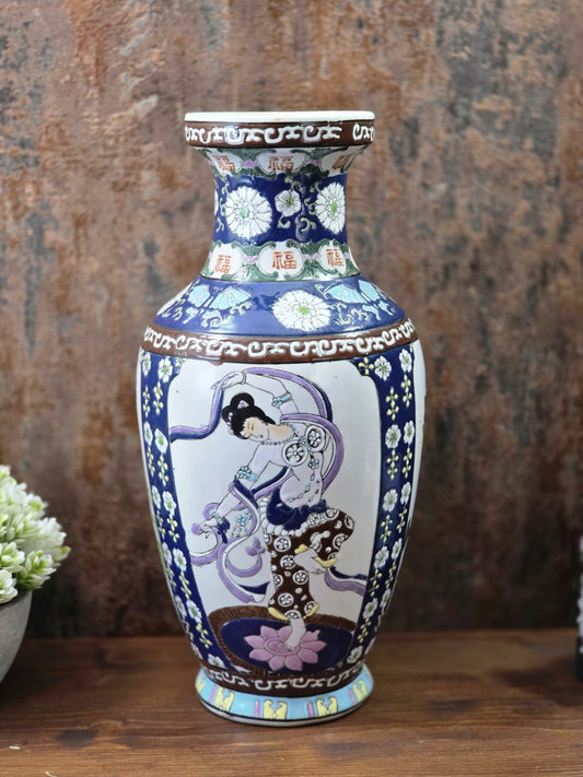 Vintage chinesische Porzellanvase mit Tänzerin, kobaltblauem Blumendekor und 福-Zeichen in frontaler Gesamtansicht auf Holztisch.