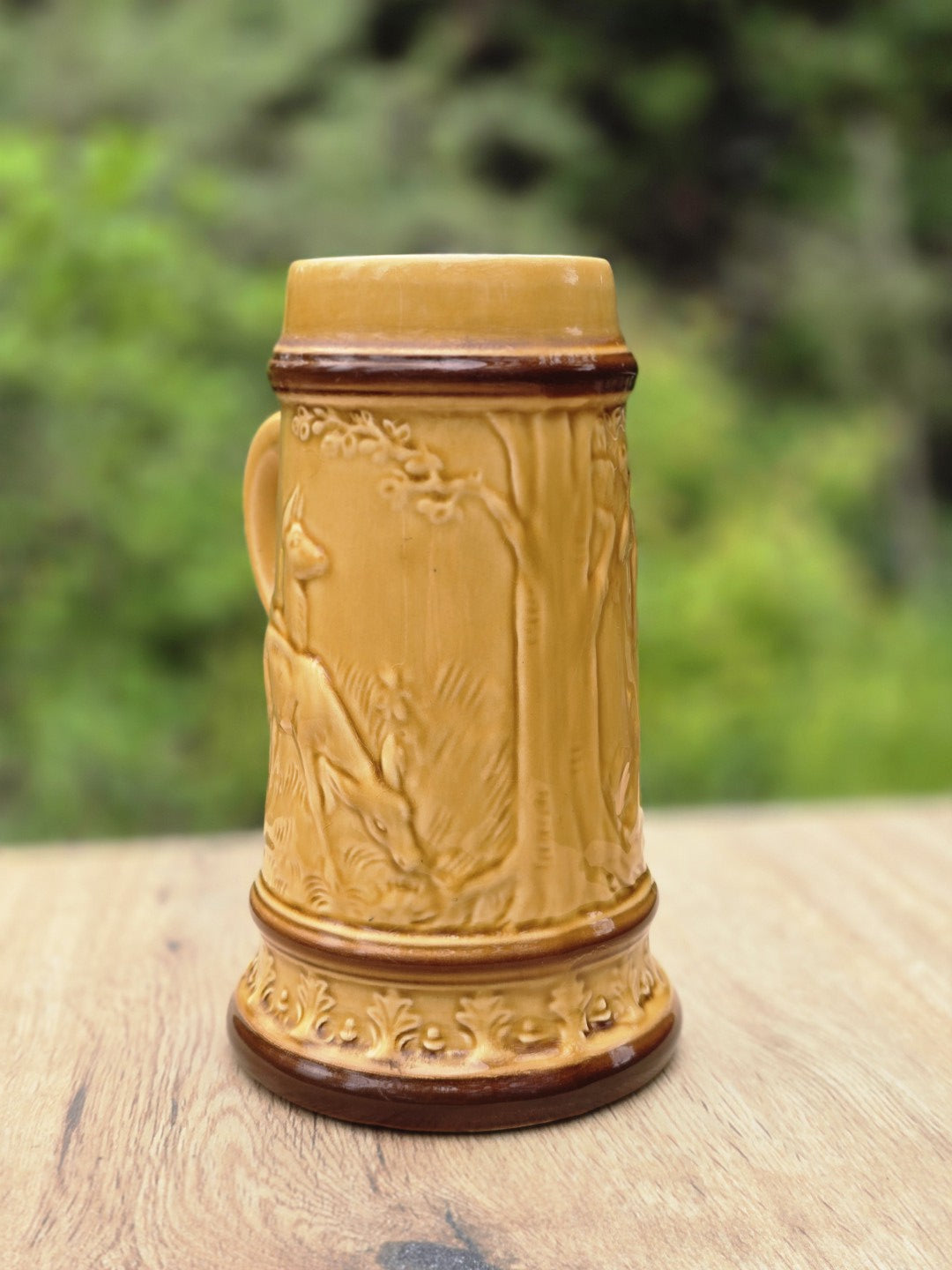 Detailreiche Rückseite des Vintage Bierkrugs mit Hirsch- oder Rehrelief, Baumdekor und honiggelber Glasur