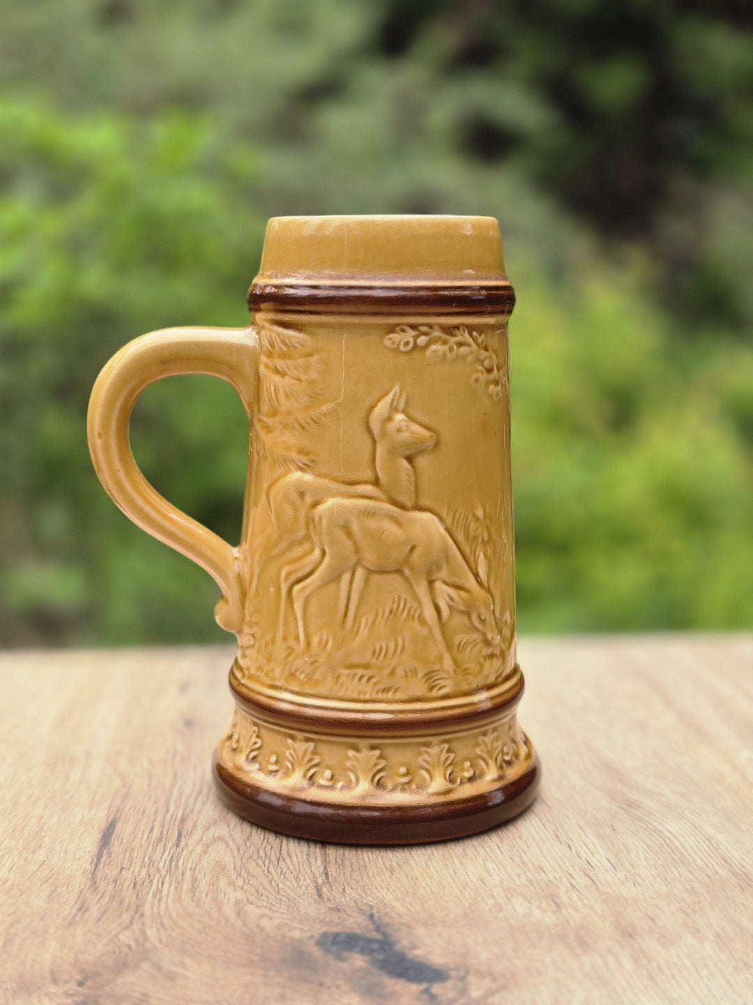Detailreiche Rückseite des Vintage Bierkrugs mit Hirsch- oder Rehrelief, Baumdekor und honiggelber Glasur