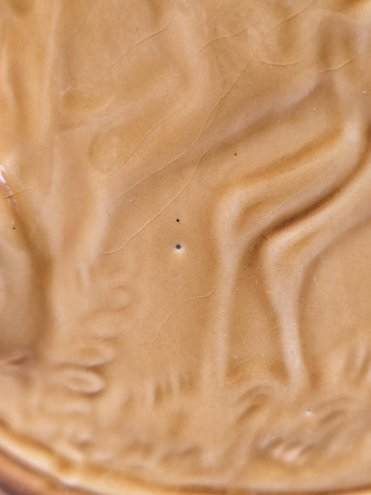 Detail der Keramikglasur mit feinen Craquelé-Linien, kleinen Oberflächenspuren und erhabenem Reliefdekor