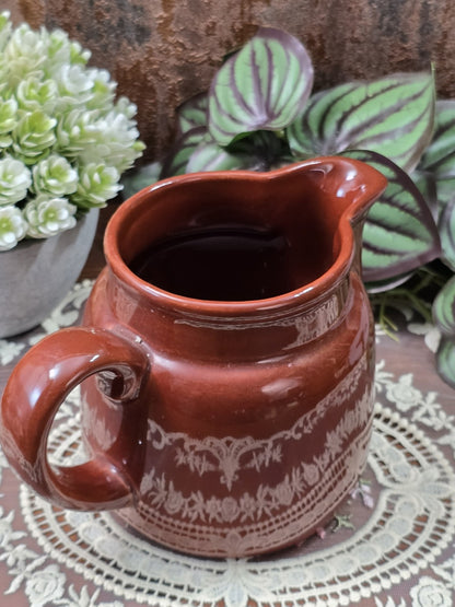 Vintage DDR Milchkännchen mit brauner Glasur, hellem Bordürendekor und breitem Henkel, von schräg oben mit Blick in den Innenraum