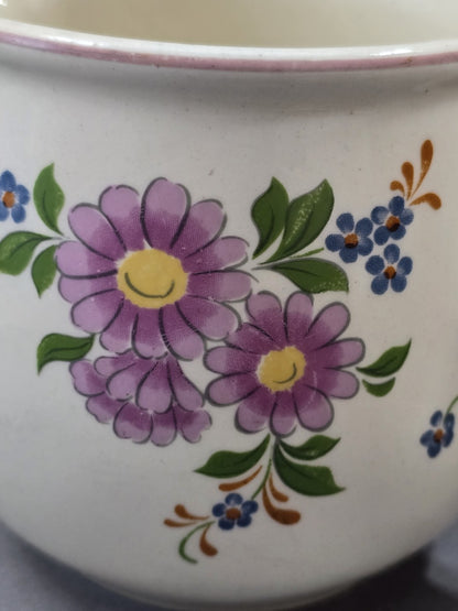 Nahaufnahme des oberen Randes mit rosa Linie, heller Keramikglasur und angeschnittenem Blumenmotiv