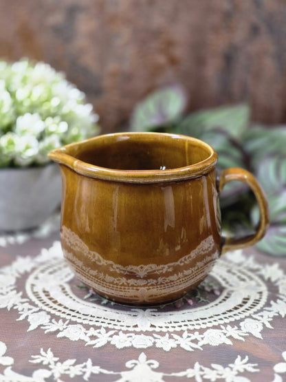Vintage DDR Milchkännchen aus honigbraun glasierter Keramik mit Henkel, Ausguss und heller Ornamentbordüre in Frontalansicht