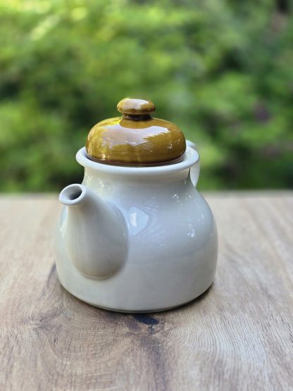 Vintage Teekanne in Cremeweiß mit olivgrünem Deckel, Ausguss und glänzender Glasur.