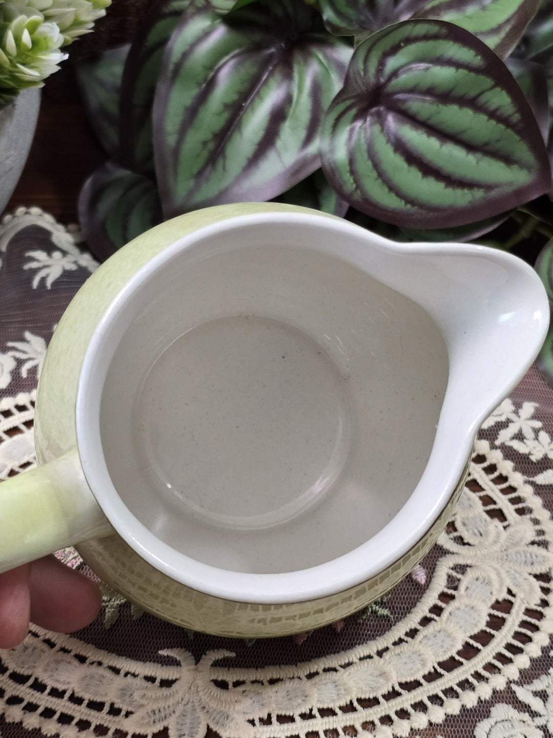 Vintage Keramik Milchkännchen in Pastellgrün mit weiß glasiertem Innenraum und geschwungenem Ausguss, von oben fotografiert