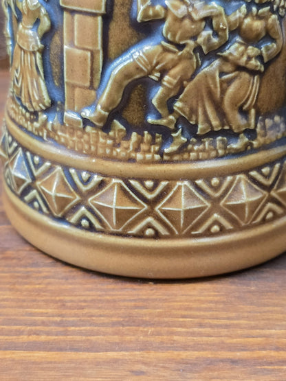 Vintage Steinzeug-Bierkrug von Gerzit mit Reliefdekor aus Figuren und geometrischem Musterband am unteren Rand in Detailaufnahme.