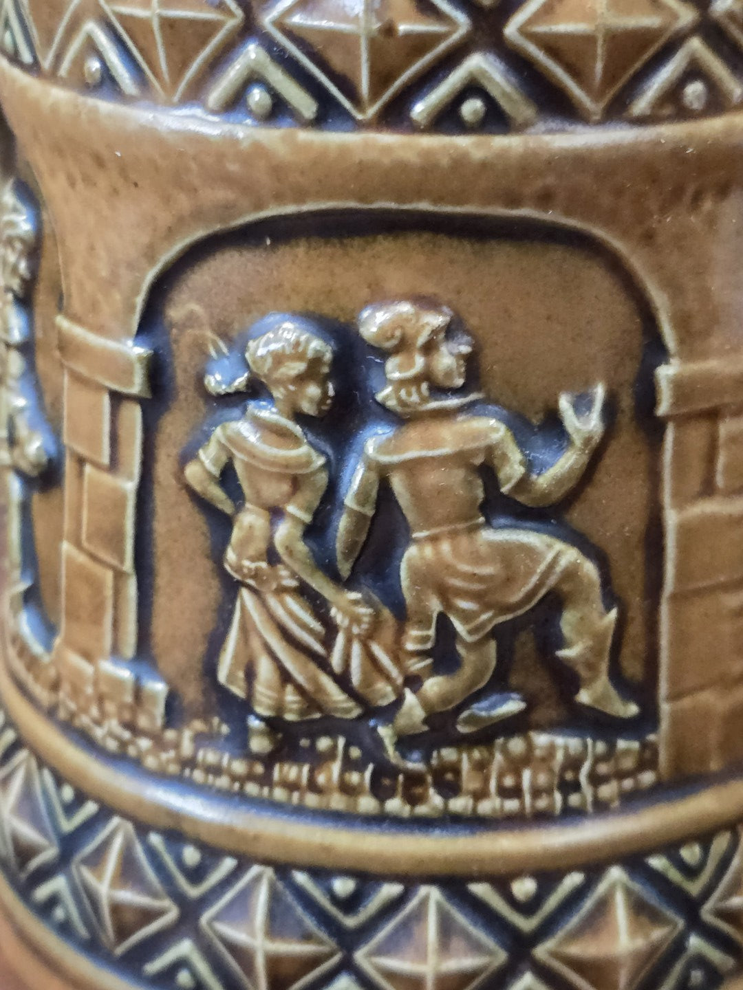 Vintage Steinzeug-Bierkrug von Gerzit mit Reliefszene eines Paares in historisierender Kleidung und umlaufendem Musterband im Detail.