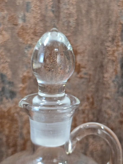 Vintage Glasdekanter im Detail mit klarem Glasstöpsel, mattiertem Schliff und seitlichem Henkelansatz