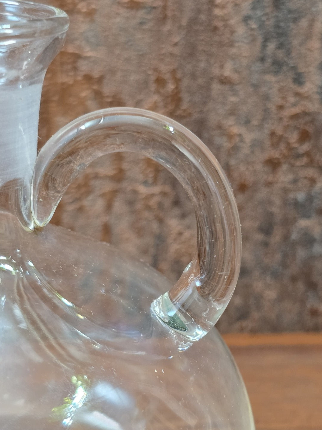 Vintage Glasdekanter im Detail mit transparentem Henkel, klarem Glas und sichtbaren Lichtreflexen