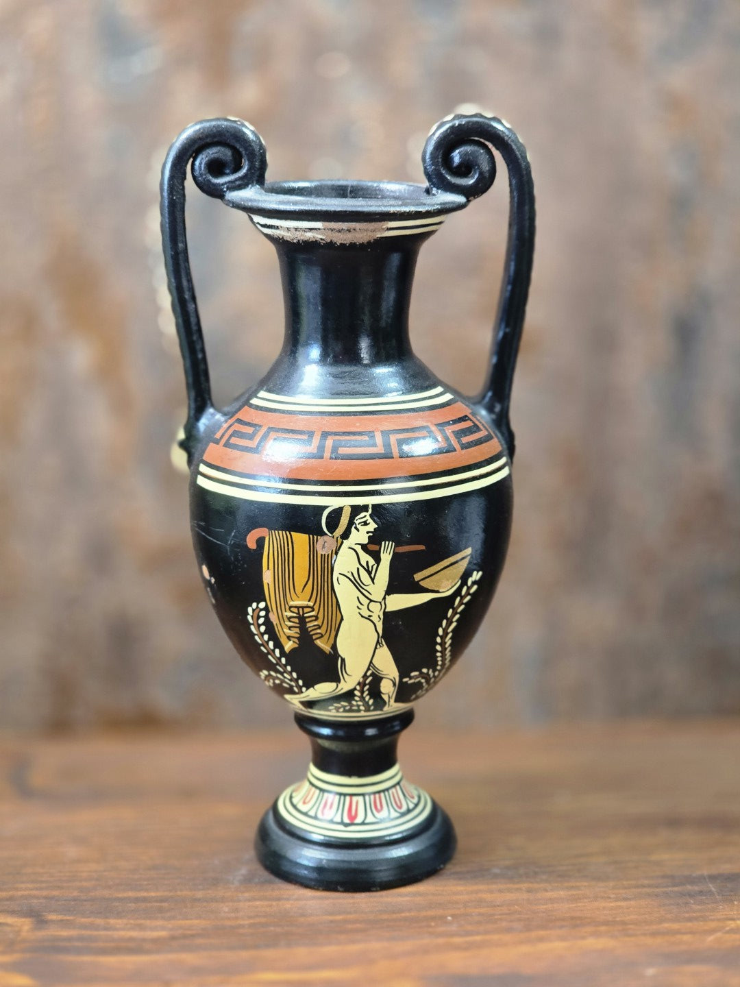Vintage griechische Keramikamphora mit schwarzem Grund, Mäanderband, Figurenmotiv und zwei Volutenhenkeln in Frontalansicht