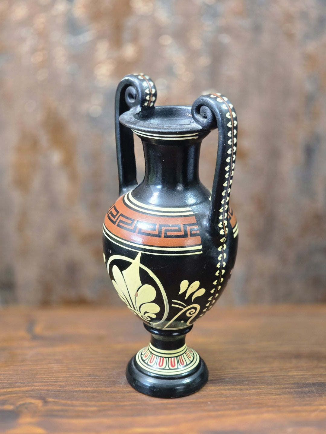 Vintage Keramikamphora mit zwei Volutenhenkeln, schwarzem Grund und cremefarbenem Palmettenmotiv in schräger Rückansicht