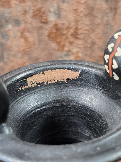 Keramikamphora mit Blick in die schwarze Gefäßöffnung und sichtbarer Farbabplatzung am oberen Innenrand in Detailaufnahme