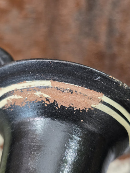 Vintage Keramikamphora mit deutlicher Farbabplatzung am oberen Rand und sichtbaren cremefarbenen Dekorlinien in Nahaufnahme