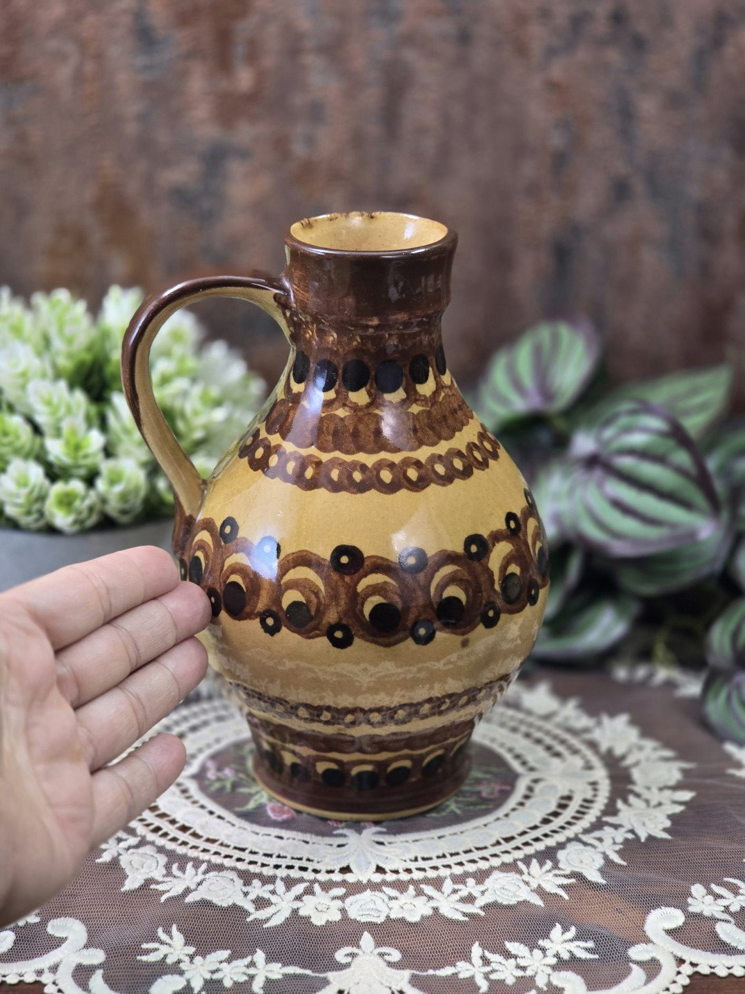 Vintage Keramik-Henkelkrug mit braunem Hals und gemustertem Korpus in Ocker, Braun und Schwarz von der gegenüberliegenden Seite.