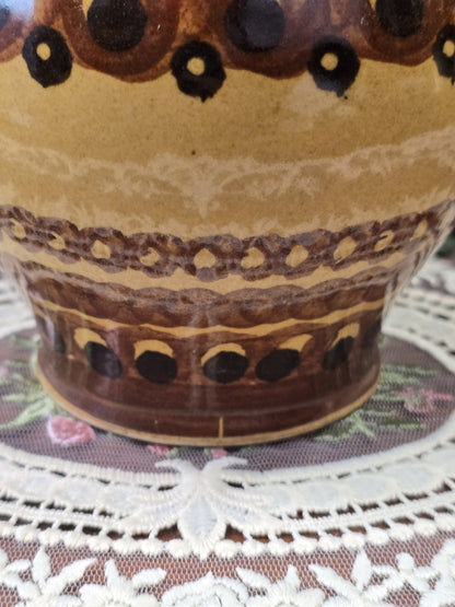 Vintage Keramik-Henkelkrug mit braunem Henkelansatz und geometrischem Dekor in Ocker, Braun und Schwarz in Detailansicht.