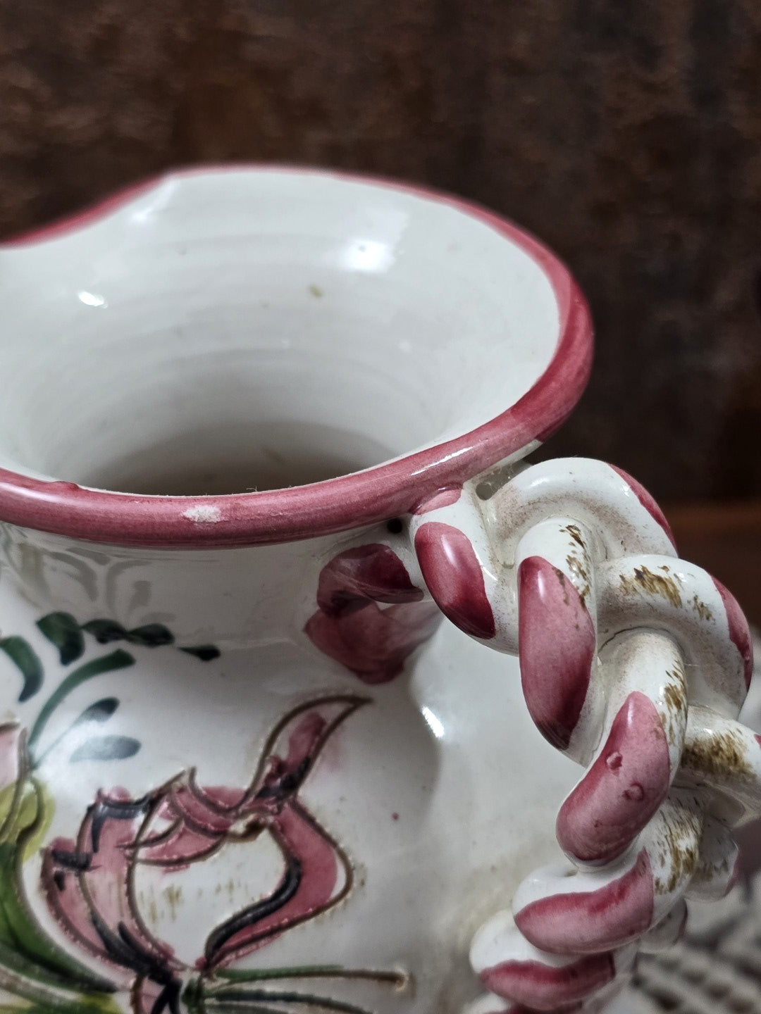 Keramik Kännchen mit geflochtenem Henkel, rosa Bemalung und sichtbaren Gebrauchsspuren in Nahaufnahme