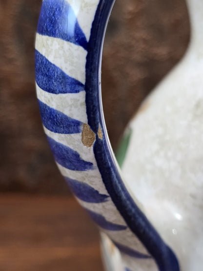 Vintage Keramik Krug im Detail mit blau-weiß gestreiftem Henkel, kleinem Farbabplatzer und heller Glasur
