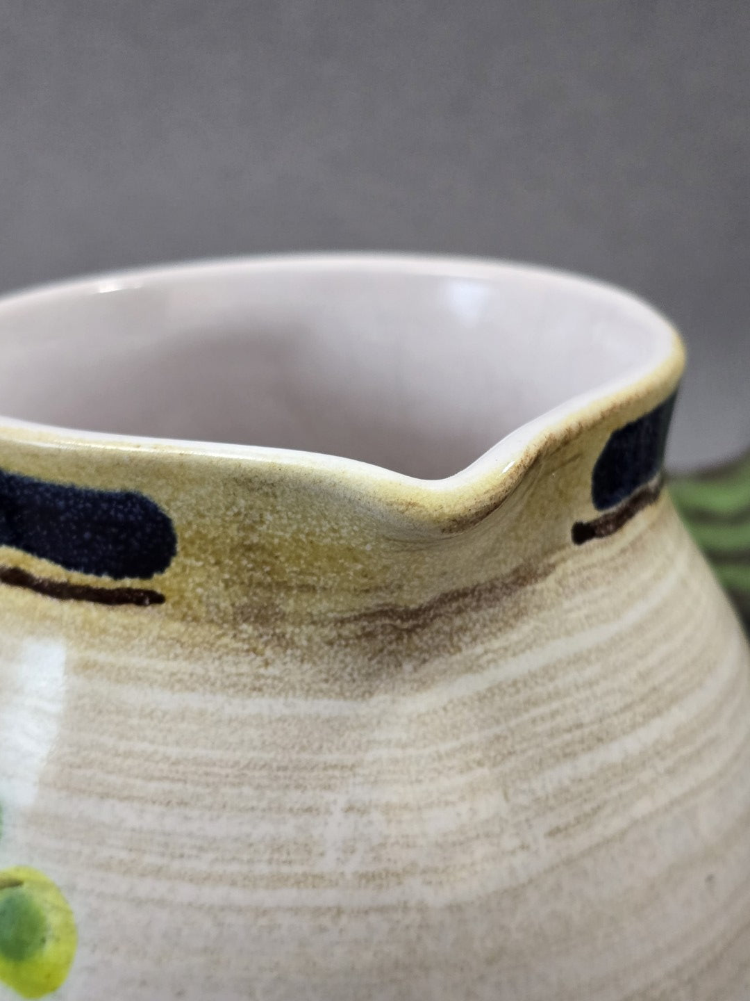Detail des Ausgusses mit hellem Innenraum, feinem Craquelé und blauem Glasurband am Keramik-Milchkännchen