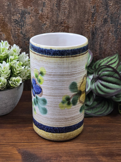Vintage Keramikvase von der Rückseite mit beigefarbenem Grund, grünen und blauen Blütenelementen sowie dunkelblauen Randstreifen.