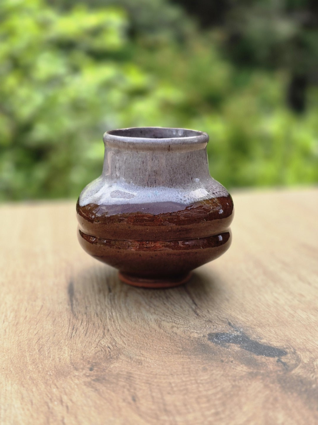 Vintage Keramikvase in Braun und Grau, frontal fotografiert mit runder Form und weichem grünem Hintergrund